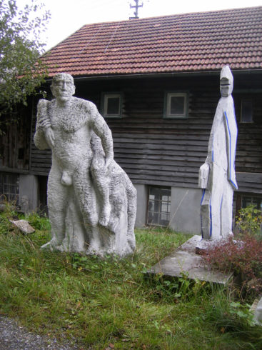 Zwei Arbeiten hinter dem Atelier: Amor & Psyche, Carraramarmor, 205 x 60 x 90 cm, 1989 (links), Schreitende Schmalfigur, Carraramarmor, 200 x 70 x 25 cm, 1994 (rechts); Foto: Anita Brockmann