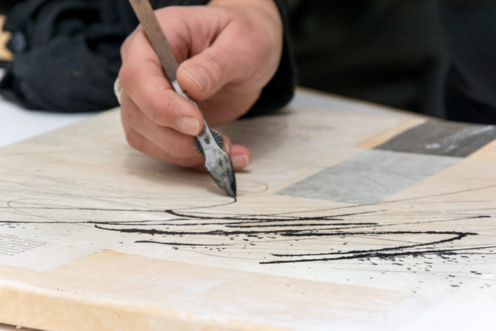 „Dem Wunder leise wie einem Vogel die Hand hinhalten.“ Mit Ziehfeder und Airbrushfarbe setzt Birgit Nass das für sie zentrale Wort „Wunder“ aus einem Vers von Hilde Domin um. Ganz bewusst spielt sie dabei mit dem Effekt, dass die Airbrushfarbe auf dem Japanpapier verläuft, mit dem die Leinwand beklebt wurde.